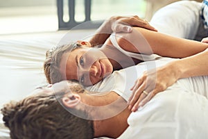 Love is always worth staying in. a happy young couple relaxing in bed together at home.