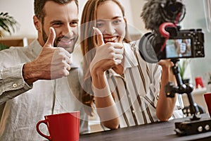 We love you! Couple of cheerful bloggers and smiling on camera while making a new video for blog