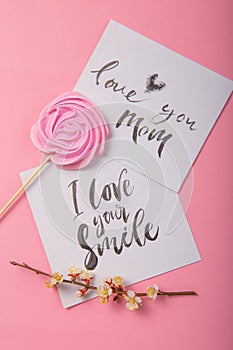 Love you mom  handwritten inscription. Hand drawn lettering,  calligraphy. card with spring tree brunch background, Valentine,