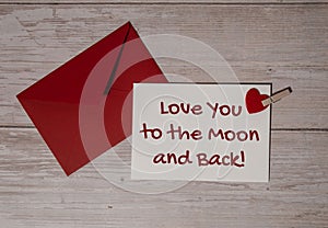 LOVE YOU TO THE MOON AND BACK text on valentine card inscription positive quote phrase. Greeting card with red envelope