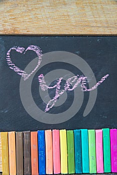 Love you written on blackboard with multi-colored chalk