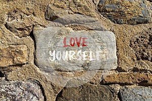 Love yourself symbol. Concept words Love yourself on beautiful grey stone. Beautiful brown stone wall background. Psychology love