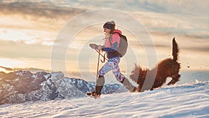 Lovebirds girl and her dog play in the snow during a winter hike