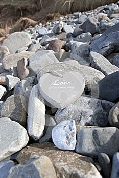 Loveing wooden heart on the rocks