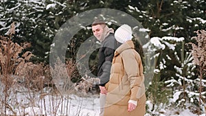 Loveling couple of young people hav date in forest in winter