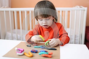 Lovely 2 years boy with playdough at home