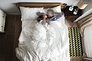 Lovely African American couple snuggling in bed