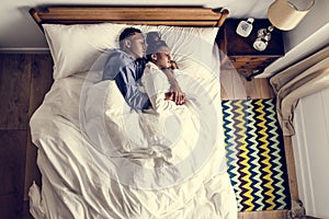 Lovely African American couple snuggling in bed