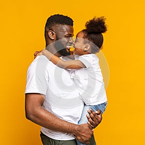 Lovely african american daddy and daughter touching noses and cuddling