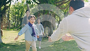Lovely asian boy running toward father in park