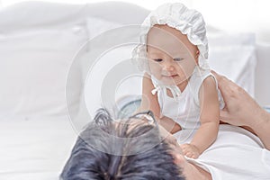 Lovely Asian little girl smiling with her father. Daddy holding and hug little baby on his body. Family having a happy time.