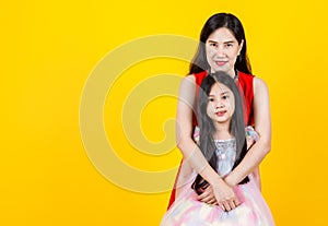Lovely Asian mother cherish cute daughter as sweetheart by kindly hug from back with warm family love and empathy care of child