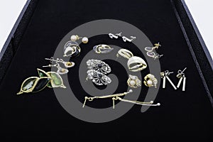An lovely assortment of antique ladies dress earings laid out on a black jewellers display board ready for restoration