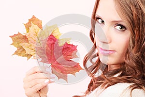 Lovely autumnal girl with maple leaves in hand