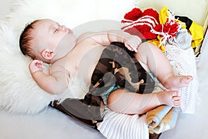 Lovely baby age of 3 months sleeping in suitcase with clothes