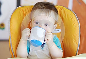 Lovely baby boy drink from baby cup