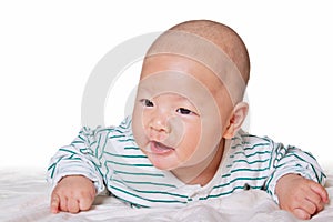 Lovely baby boy groveling on bed