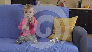 Lovely baby get tv remote control and concentrate on watching television