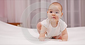 Lovely baby playing at home in bedroom looking at camera smile 9 months happy baby playing. Lovely baby girl crawling in