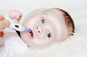 Lovely baby take temperature with electronic thermometer