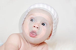 Lovely baby in white knitted hat