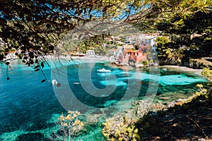 Lovely bay of assos village, Kefalonia, Greece. View on tourquise transparent water framed between green pine grove