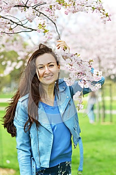 Lovely Beautiful Caucasian Woman Standing Posing on the Background of Blooming Japan Cherry