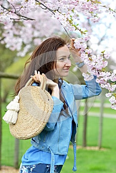 Lovely Beautiful Caucasian Woman Standing Posing on the Background of Blooming Japan Cherry