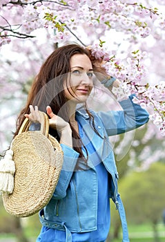 Lovely Beautiful Caucasian Woman Standing Posing on the Background of Blooming Japan Cherry