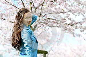 Lovely Beautiful Caucasian Woman Standing Posing on the Background of Blooming Japan Cherry