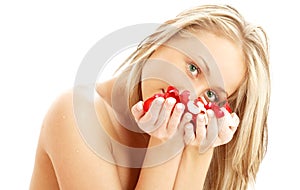 Lovely blond in spa with red and white rose petals