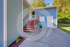 Lovely blue home exterior features red staircase