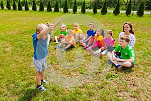 Lovely boy standing in front of group of kids