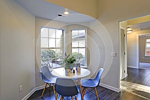 Lovely breakfast nook with white round table and blue chairs.