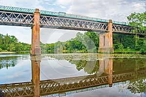 A lovely bright June evening with the viaduct bridge reflected in the lily covered lake, Sussex England