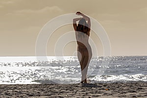 Lovely Brunette Bikini Model Relaxing On The Shoreline At Sunset