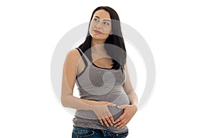 Lovely brunette pregnant woman touching her belly and looking away isolated on white background