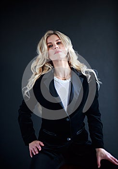 Lovely business lady in black suit, portrait woman with long blond curly hair