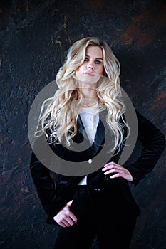 Lovely business lady in black suit, portrait woman with long blond curly hair