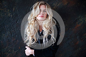 Lovely business lady in black suit, portrait woman with long blond curly hair