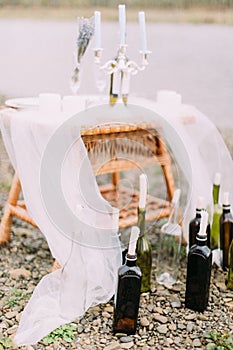 Lovely candle stands in the form of glass bottles on the beach.