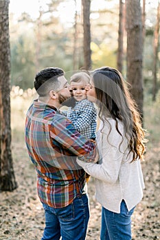 Lovely Caucasian family, handsome bearded father, pretty brunette woman mother, and cute little baby son, having fun