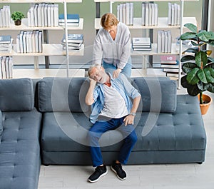 Lovely caucasian senior elderly wife standing massage happy white hair and bearded husband shoulder sitting relaxing resting on