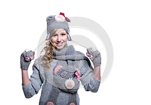 Lovely cheerful teenage girl wearing fuzzy sweater, scarf, mittens and hat isolated on white background. Winter clothes.