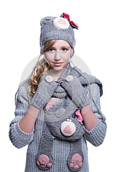 Lovely cheerful teenage girl wearing fuzzy sweater, scarf, mittens and hat isolated on white background. Winter clothes.