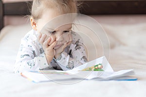Lovely children - brother and sister, reading a book, on the bed. Close up of children in bed reading a book. A boy and
