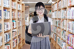 Lovely college student in library aisle