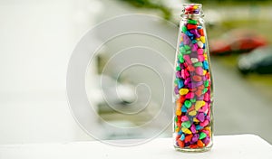 Lovely colorful small pebbles with  in a clear glass bottle