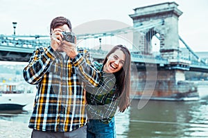 Lovely cople taking picture bridge on background