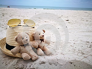 Lovely couple bear on white sand beach with Hat and sun glasses at Hua Hin beach, item and accessories for summer vacation and hol